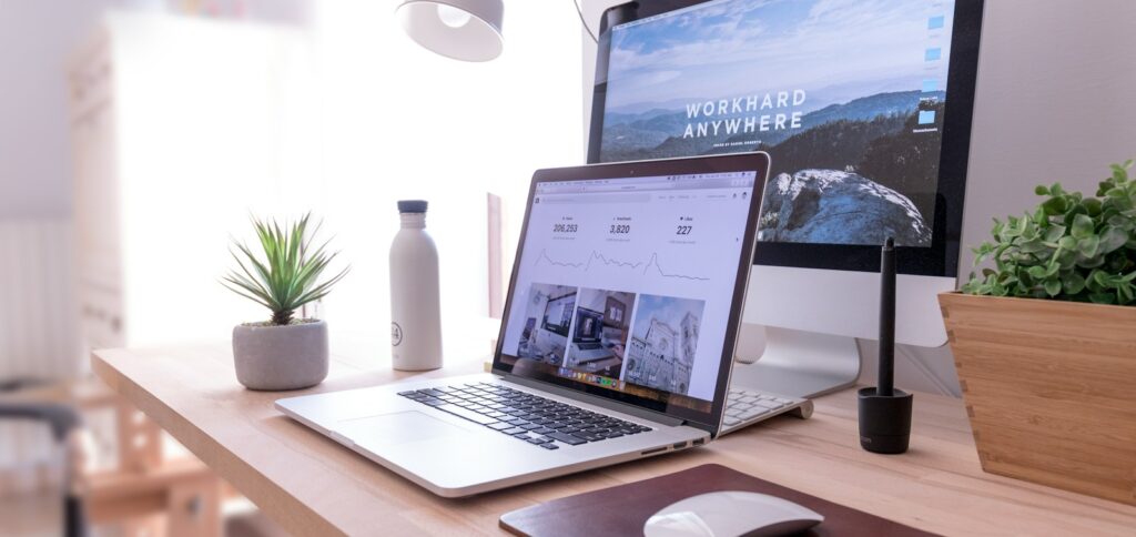 MacBook Pro on table beside white iMac and Magic Mouse
